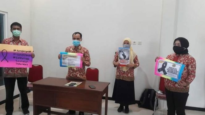 Dengan membawa poster, Belasan anggota DPD PPNI Rembang mengecam tindakan warga yang menolak pemakaman jenazah perawat positif Corvid-19 (Foto:Istimewa)