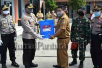 Kapolres Demak AKBP R Fidelis Purno Timuranto menyerahkan perlengkapan kesehatan kepada perwakilan Desa yang menjadi Kampung Siaga Corvid-19 (Foto:J02)