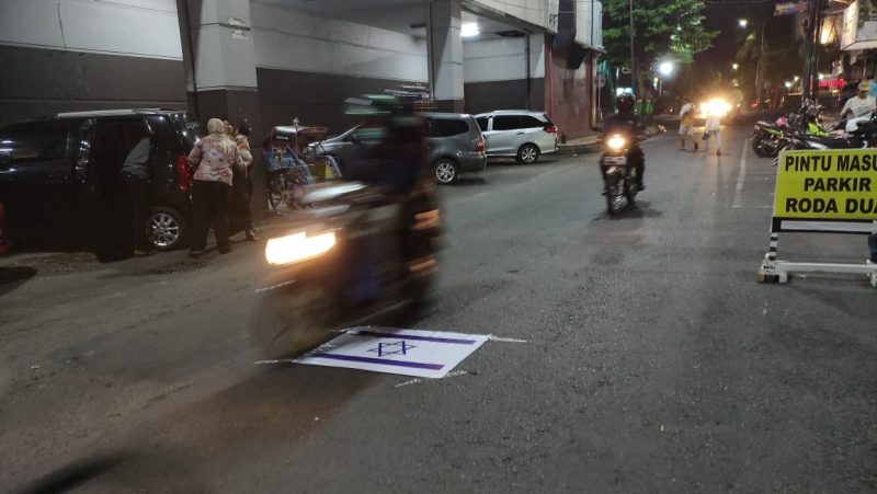 Replika bendera Israel tertempel di jalan belakang Ramayana terinjak roda kendaraan (Foto:J02)