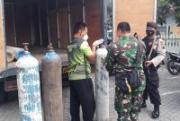 Personil bersenjata melakukan pengawalan pengisian tabung oksigen (Foto:Istimewa)