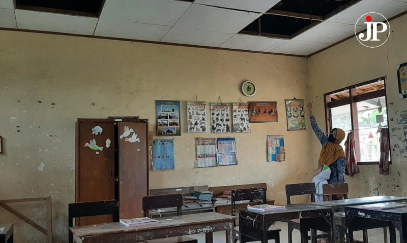 Masriah, guru pengajar PPKN menunjukkan atap yang runtuh dan timpa siswa (Foto:J02)