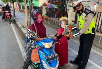 Tertib berlalu lintas dengan memakaikan helm pada anak, pengendara ini terima hadiah (Foto:Istimewa) 