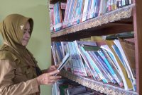 Kepala SDN 1 Jati Kulon Sri Wahyuningsih tengah membaca buku di perpustakaan sekolah. (J05)