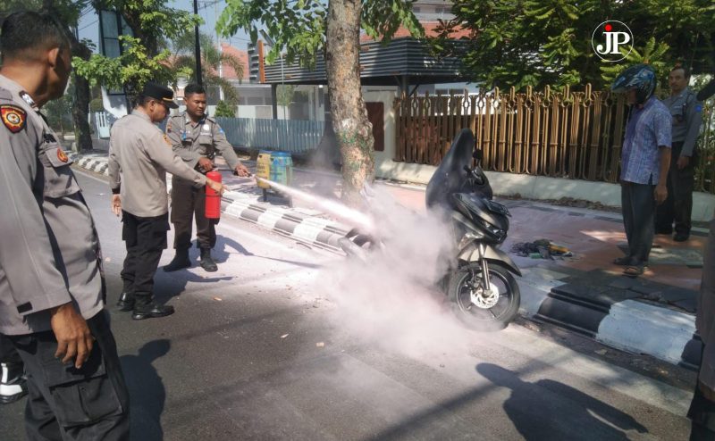 Polsek Kudus Kota memadamkan sepeda motor yang tiba-tiba terbakar. (Foto:Istimewa)
