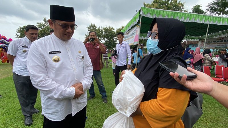 Pj Bupati Kudus M Hasan Chabibie saat berinteraksi dengan Rahayu yang membeli paket sembako murah di Pasar Murah. (Foto:J05)