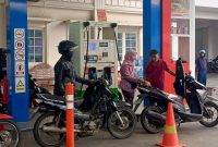 Nampak petugas perempuan operator SPBU di Getas Pejaten Kudus dengan memakai pakaian kebaya sedang melayani konsumennya. 