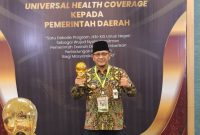 Pj Bupati Kudus, M Hasan Chabibie saat menerima Penghargaan UHC Awards Tahun 2024. (Foto:Istimewa/Diskominfo)