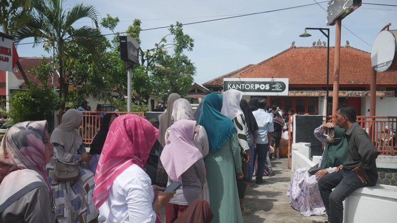 Warga nampak antre panjang untuk mencairkan bantuan PKH dan BPNT di Kantor Pos Jati, Kudus. (Foto: JP)