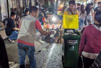 Petugas memunguti sampah dan membawa tong sampah keliling di Dandangan. (Foto: JP)