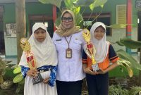 Kepala SD 1 Tumpangkrasak, Briari Indrastiati bersama Bilqis Hafidza Nuri Maulida peraih juara 1 menulis cerita (kanan) dan Lutfiya Aqila Ufaira peraih juara 2 kriya (kiri) dalam ajang FLS3N tingkat Korwil Pendidikan Kecamatan Jati, Kudus. (Foto: J05)