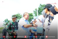 Ketua DPRD Kudus, H. Masan SE.MM ikut membagikan sepatu bagi para siswa berprestasi saat pembukaan TMMD di Kandangmas, Kudus (Foto:JP)