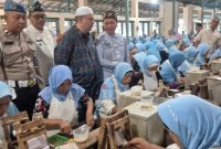 Bupati Kudus Samani Intakoris didampingi Helmi Tasan Wartono, perwakilan Direksi PT Sukun, dan Camat Gebog Fariq Musthofa saat meninjau langsung penyaluran BLT DBHCHT tahap dua kepada buruh rokok di area produksi PT Sukun. (Foto: JP)