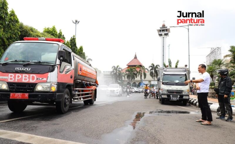 Bupati Kudus Sam’ani Intakoris mengecek penyemprotan air bersih di Simpang Tujuh (Foto:JP)