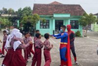 Petugas SPPG Al Chalimi 2 Desa Bulungcangkring mengenakan kostum superhero saat mendistribusikan menu MBG ke sekolah. (Foto: J05)