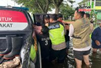 Personil Polsek Jati mengevakuasi warga stroke ditengah banjir (Foto:JP)
