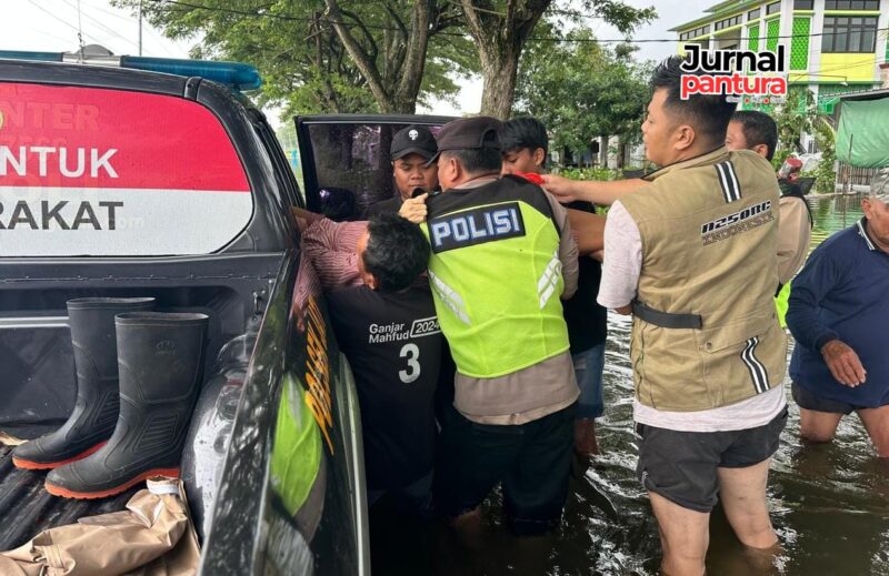 Personil Polsek Jati mengevakuasi warga stroke ditengah banjir (Foto:JP)