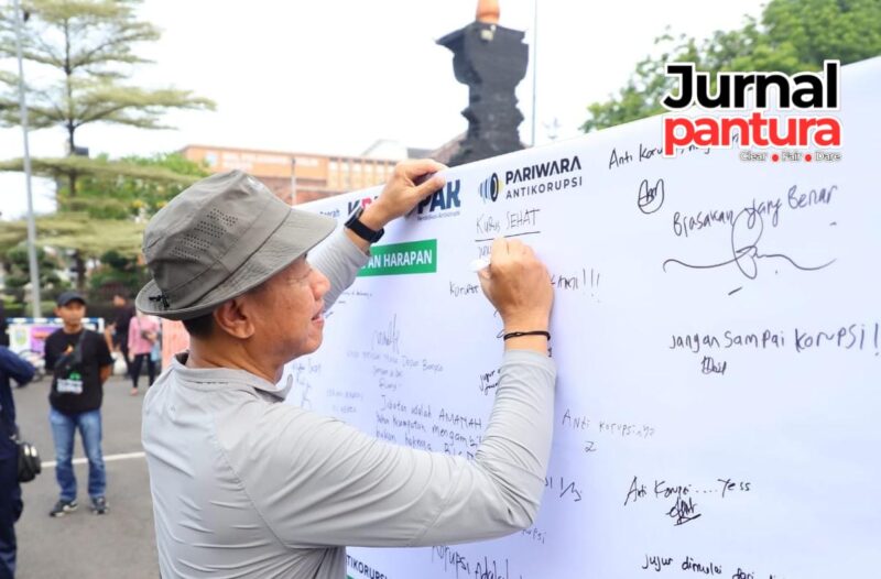 Bupati Kudus Sam’ani Intakoris menandatangani pariwara antikorupsi saat kegiatan sosialisasi antikorupsi yang digelar Inspektorat Kabupaten Kudus di area Car Free Day (CFD), Minggu (24/5). Penandatanganan tersebut menjadi bentuk komitmen Pemkab Kudus dalam mewujudkan pemerintahan yang bersih dan bebas korupsi. (Foto: JP)