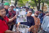 Warga menunjukan foto-foto kerusakan jalan (Foto:JP)