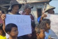 Warga protes bentangkan spanduk (Foto:JP)