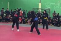 Peraih medali emas SEA Games, Safira Dwi Meilani (merah), berhadapan dengan pesilat PSHT Cabang Pati, Septiyiana Cahaya Ningrum, pada partai utama Uji Tanding Pencak Silat yang digelar Akademi Silat Kudus (ASK) di Gedung Tenis Indoor Kabupaten Kudus, Minggu (28/6/2026). (Foto: JP)