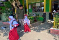 Aris Suryawan (33) mengantarkan putrinya ke sekolah pada hari pertama masuk sekolah tahun ajaran baru 2026/2027 di SD 5 Karangbener, Kabupaten Kudus. (Foto: J05)