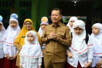 Bupati Kudus Sam'ani Intakoris mendampingi siswa pada hari pertama masuk sekolah dalam Gerakan Ayah Mengantar Anak ke Sekolah (GAMAS) di SDIT Al Islam Kudus, Senin (13/7/2026). (Foto: Diskominfo)