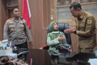 Makronah, warga Desa Gadudero, Kecamatan Sukolilo, Kabupaten Pati, mendapat kesempatan duduk di kursi kerja Bupati Kudus Sam’ani Intakoris usai menyampaikan aspirasi dalam aksi demonstrasi terkait evaluasi program MBG di depan Kantor Bupati Kudus, Senin (14/9/2026). Foto: JP