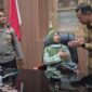 Makronah, warga Desa Gadudero, Kecamatan Sukolilo, Kabupaten Pati, mendapat kesempatan duduk di kursi kerja Bupati Kudus Sam’ani Intakoris usai menyampaikan aspirasi dalam aksi demonstrasi terkait evaluasi program MBG di depan Kantor Bupati Kudus, Senin (14/9/2026). Foto: JP