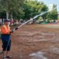 Petugas menyiram rumput di Alun-alun Simpang 7 Kudus sebagai upaya pemulihan kondisi vegetasi yang rusak akibat cuaca ekstrem dan tingginya intensitas kegiatan, Kamis (15/10/2026). Foto: JP